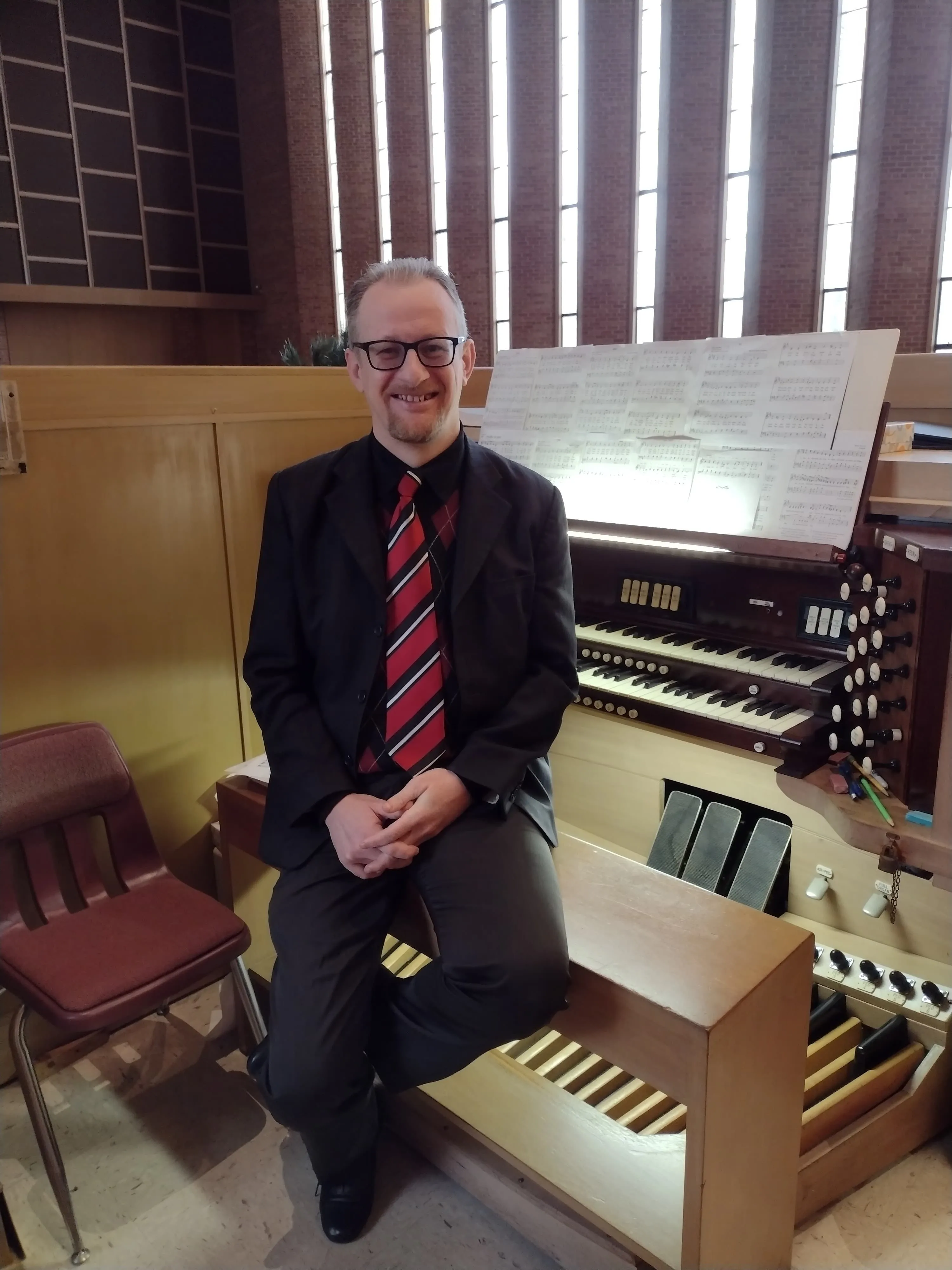 Rudimar Bonamigo, smiling, at the organ console